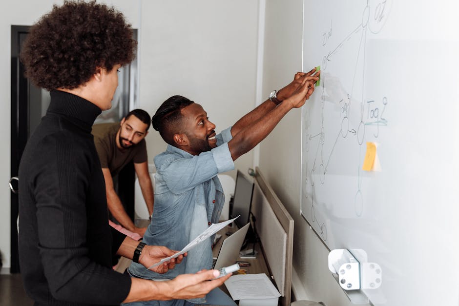 A diverse team of professionals brainstorming solutions at a whiteboard in an office setting