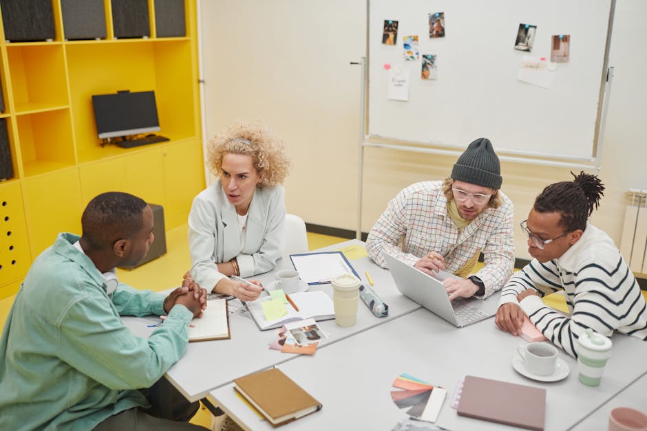 Diverse group of colleagues discussing ideas and collaborating in a bright, modern office setting